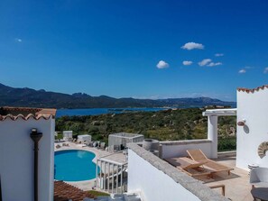 A rooftop pool area with a view of a lake and mountains. - Sulia House Porto Rotondo, Curio Collection by Hilton (Olbia)