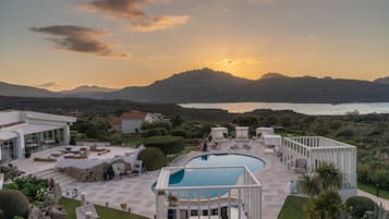 Un resort con piscina, zona de estar y vistas a la montaña.
