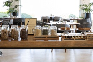 A buffet table with various food items and jars of condiments. - Sulia House Porto Rotondo, Curio Collection by Hilton (Olbia)