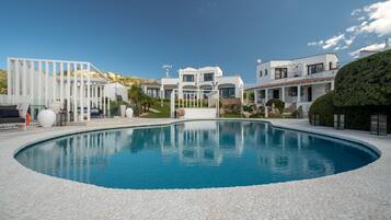 Una piscina al aire libre, camas de piscina gratis, sombrillas