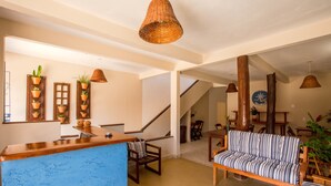 Amplia sala de estar con una pared azul decorativa, muebles de madera y una escalera que conduce a otro nivel.