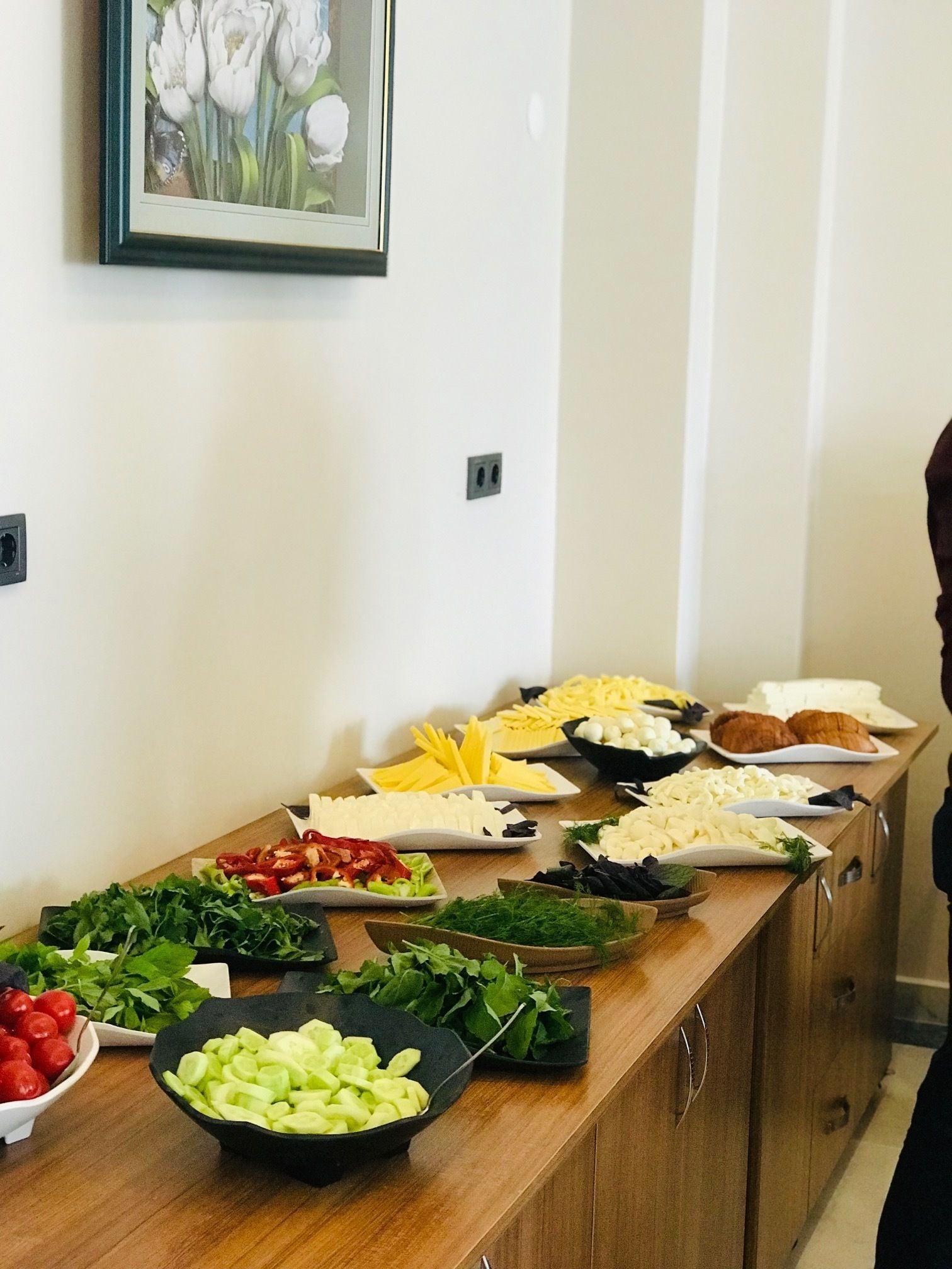 Una mesa de buffet con diversos alimentos y un cuadro en la pared.