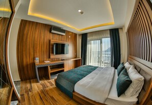 A modern hotel room with a large bed, a desk, and a TV. - Diamond Liman Hotel (Amasra)