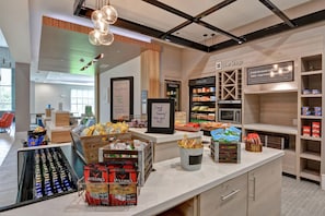 A café with a self-serve counter, a coffee shop sign, and a menu board. - Hilton Garden Inn Biloxi (Biloxi)