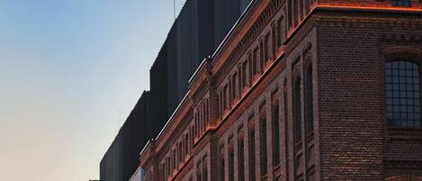 A building with a large sign reading "CAISIA ONE" and "FABRYKA 1" on its facade.