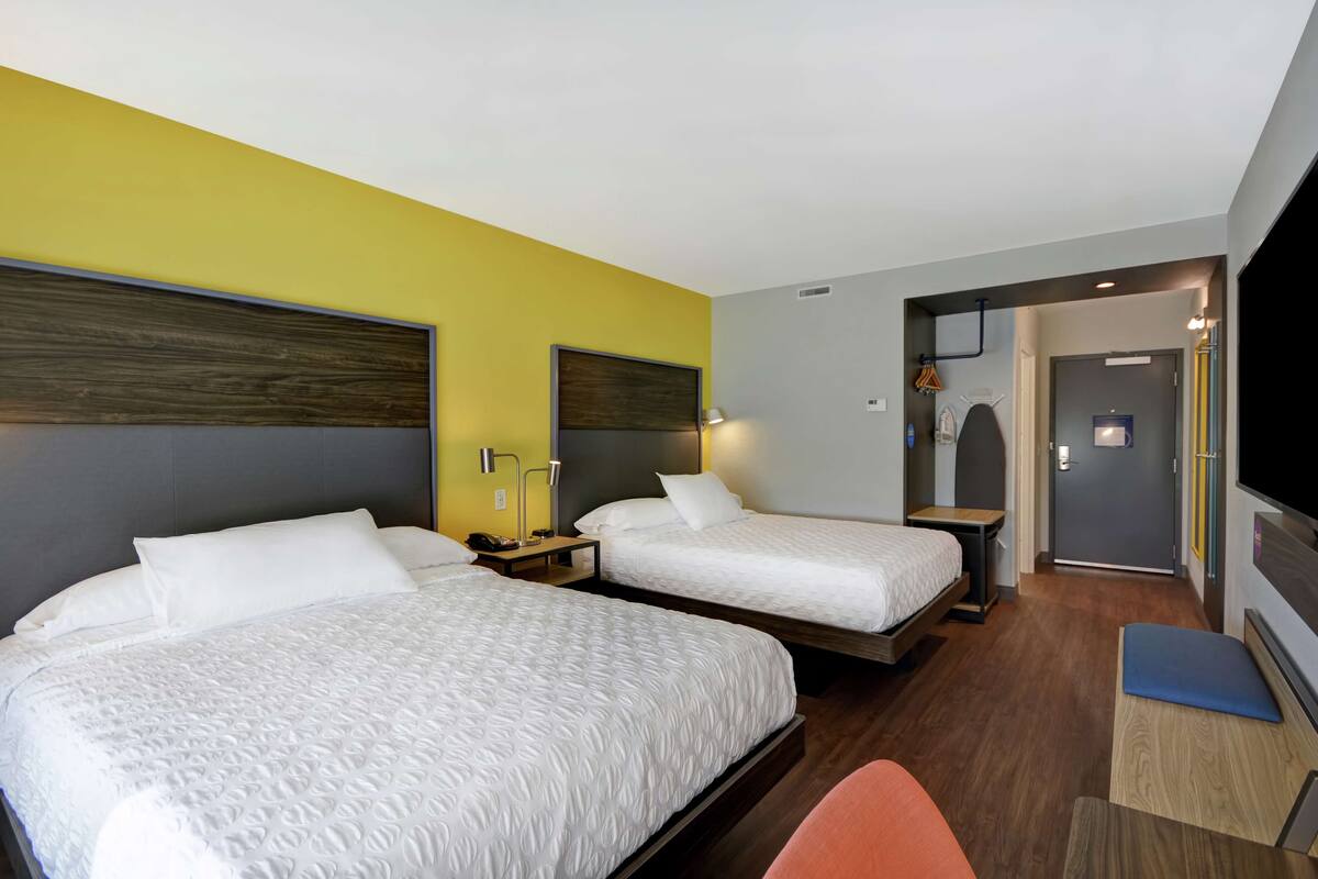 Una habitación de hotel con dos camas, un escritorio y un televisor.
