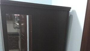 Une armoire noire à deux portes et dotée d’un petit tiroir en bas.