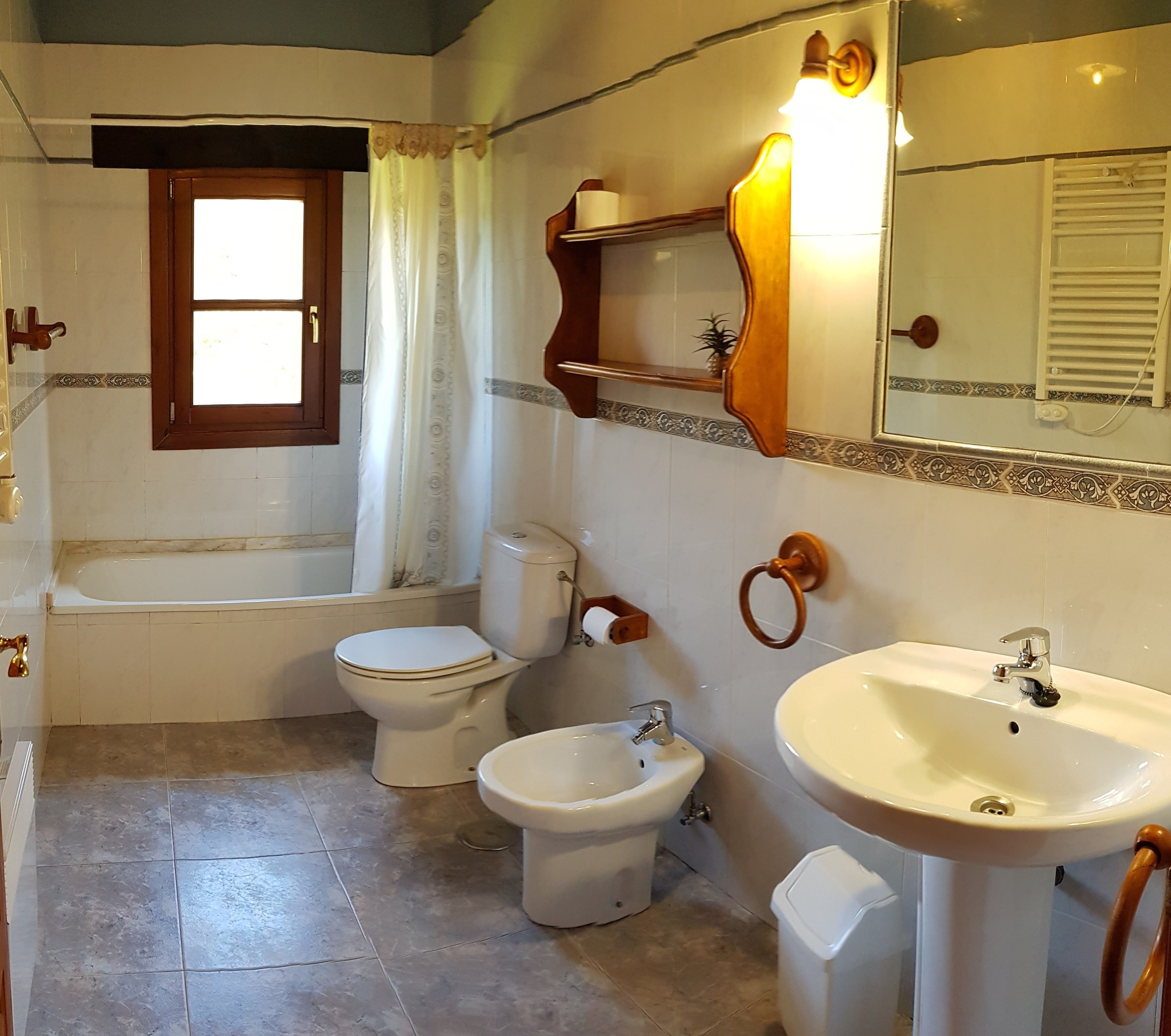 A bathroom with a bathtub, toilet, bidet, and sink.