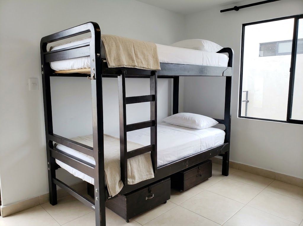 A bunk bed with a storage drawer and a window with a view.