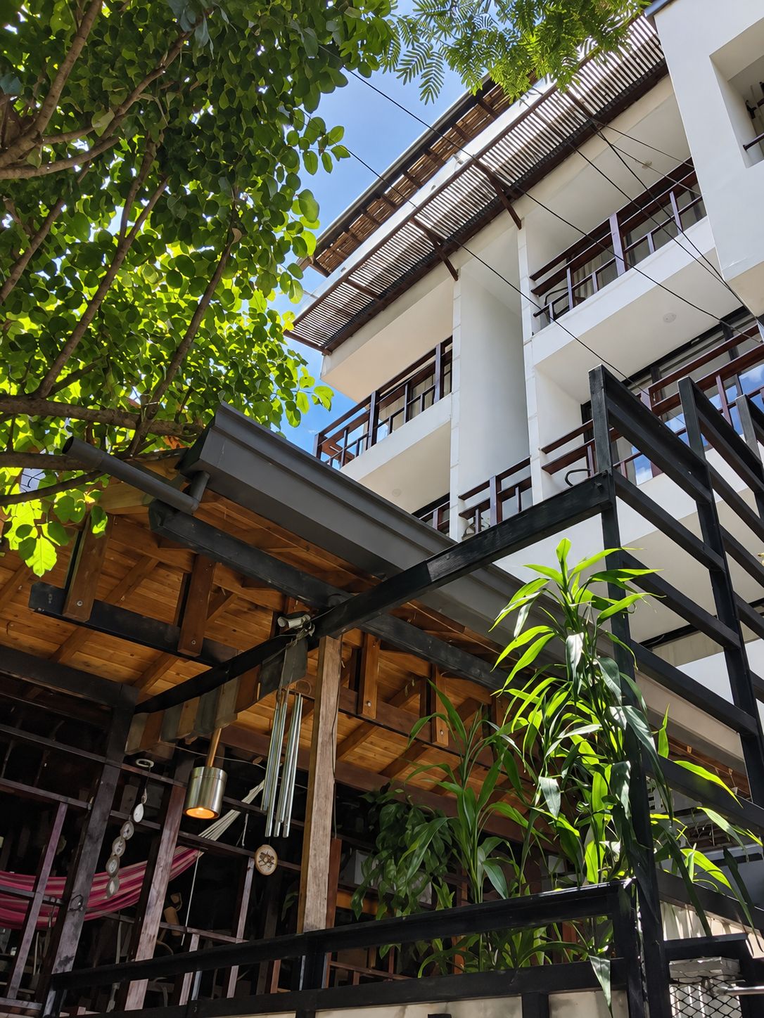 A multi-story building with a wooden deck and potted plants.