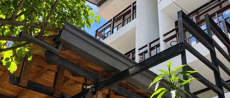 A multi-story building with a wooden deck and potted plants.
