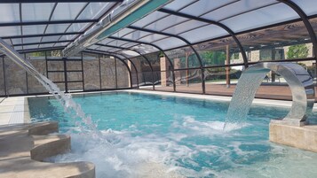 Una piscina techada, una piscina al aire libre de temporada, sombrillas