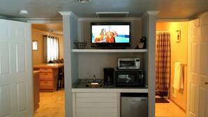 A compact kitchen with a built-in microwave, toaster, and sink. A television is mounted above the counter. - Open All Year. Ausable River Access. Newly Remodeled! (Roscommon)