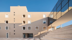 Un edificio moderno con fachada plana, múltiples ventanales y una entrada central.