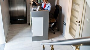 Una cocina moderna con un refrigerador de acero inoxidable, una isla blanca e iluminación colgante.
