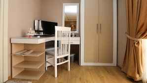 Una habitación pequeña con escritorio, silla y armario.
