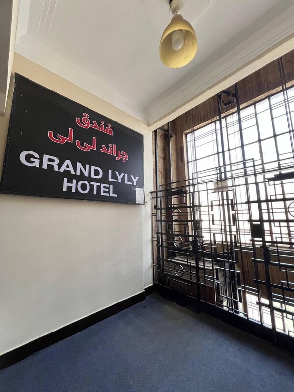 Une enseigne d’hôtel avec du texte en arabe et l’inscription « GRAND LYLE HOTEL » en anglais.