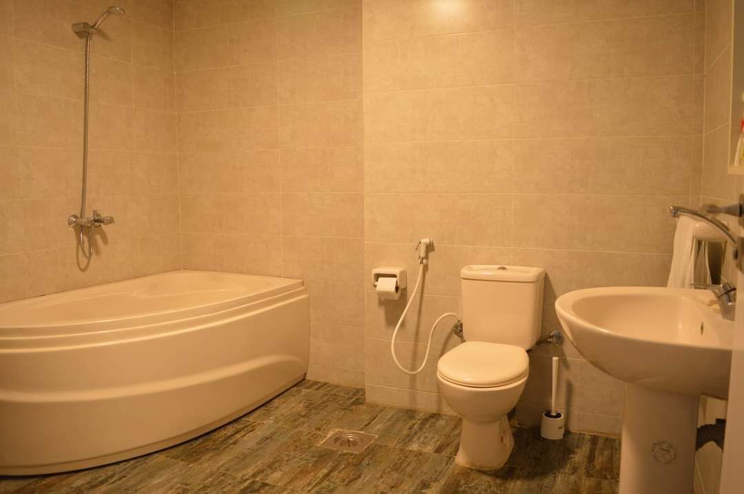 A bathroom with a bathtub, toilet, and sink.