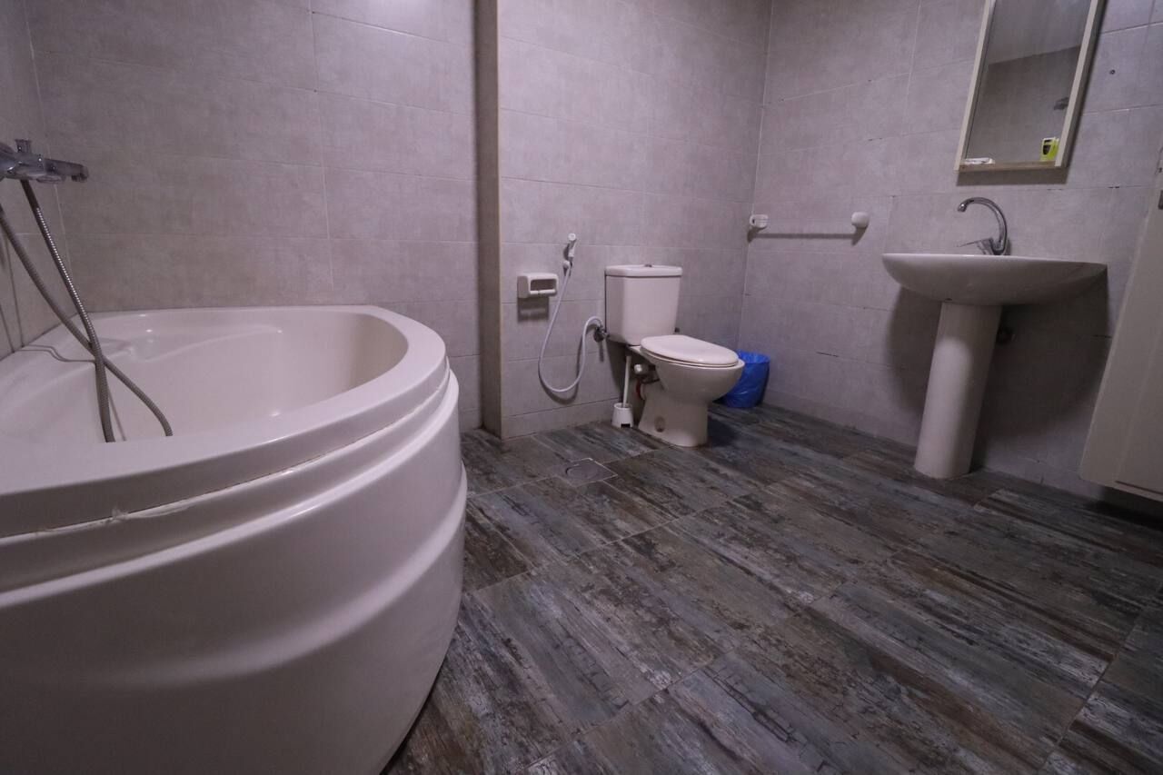 A bathroom with a large bathtub, toilet, and sink.