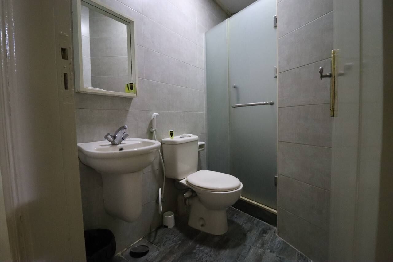 Ein kleines Badezimmer mit Waschbecken, Toilette und Duschkabine aus Glas.