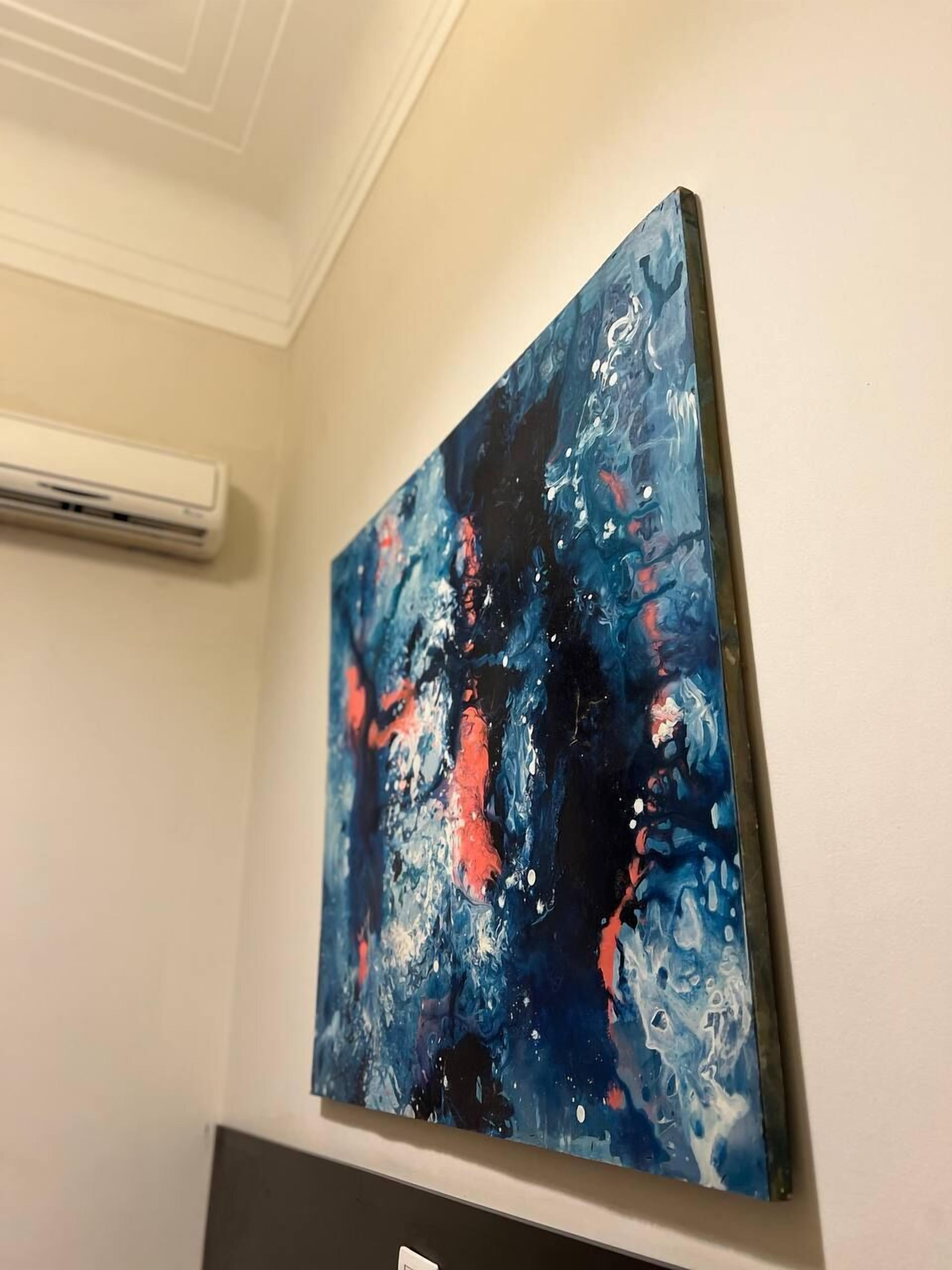 Ein Gemälde mit abstrakten blauen und roten Mustern an einer Wand.