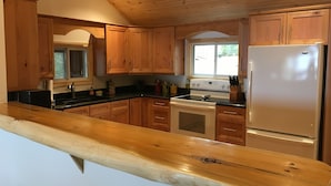 A kitchen with wooden cabinets, a stove, and a refrigerator. - Loon Lodge - Golden Lake (Cottage & Bunkie -Sleeps 8 ) (Killaloe)