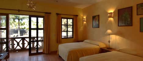 Una habitación con dos camas, un ventilador de techo, luces colgantes con forma de estrella, una ventana con cortinas y una lámpara de pared.