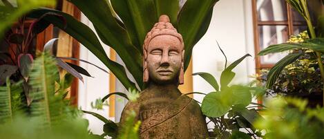 A statue surrounded by lush green foliage.