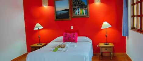 A hotel room with a bed, two nightstands, a window, and two wall-mounted lamps.