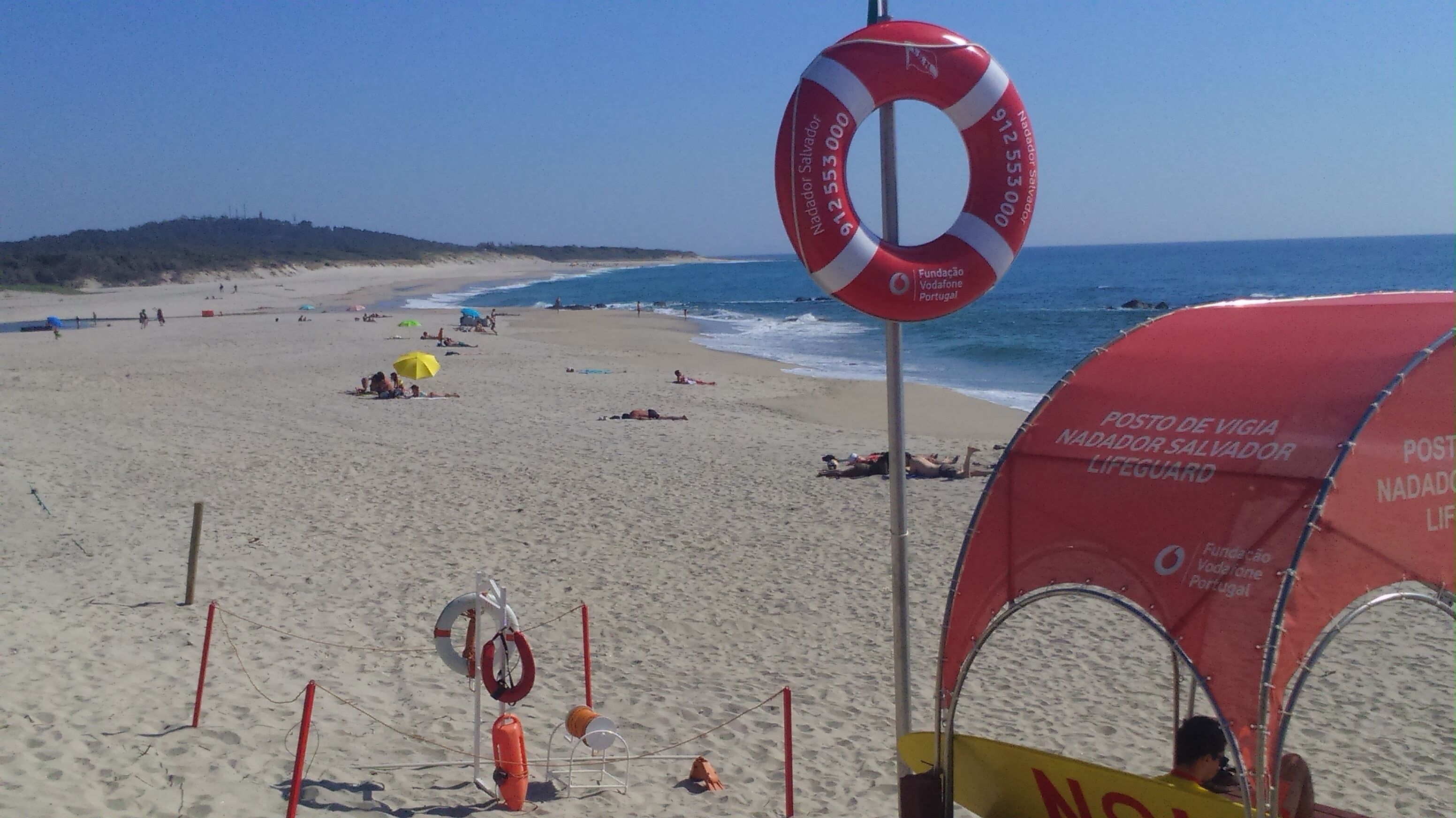 Ein Strand mit Rettungsbojen und einem Rettungsschwimmerzelt.