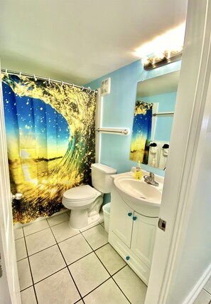 Tina con regadera, secadora de cabello, toallas 