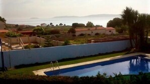 A residential area with a swimming pool, houses, and a view of the sea. - Apartamentos Mirador de Ons for 2 people (Sanxenxo)
