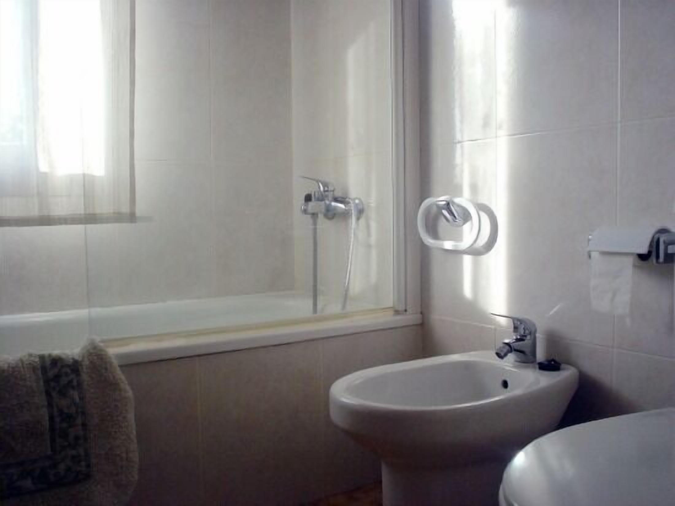 A bathroom with a bathtub, a toilet, and a bidet.