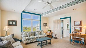 A living room with a sofa, coffee table, and a dining area with a table and chairs.