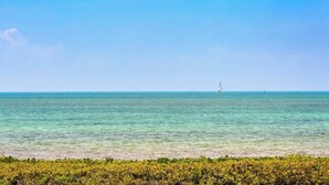 Ein freier Blick auf das Meer mit einem Segelboot in der Ferne.