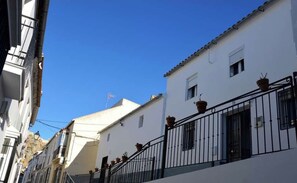 Stroll through historic streets lined with charming buildings featuring small windows and lush balconies.