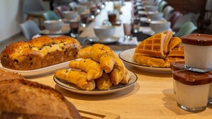 Un buffet de petit-déjeuner proposant des croissants, des gaufres et un assortiment de viennoiseries.