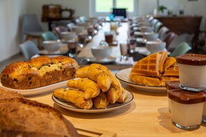 A breakfast buffet with croissants, waffles, and a variety of pastries. - Amodo Lodge - LETO Room (Saint-Paul-en-Chablais)