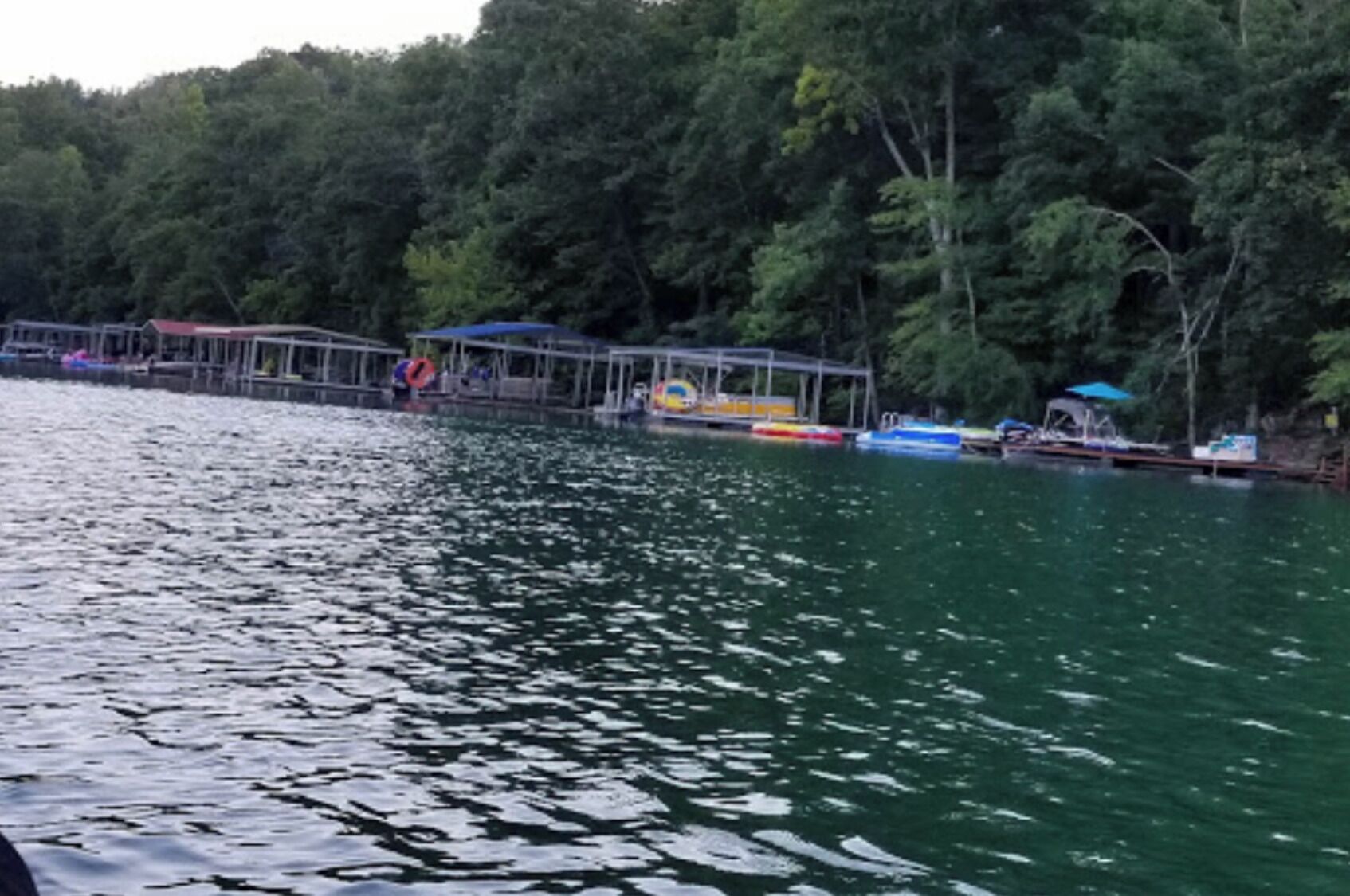 A calm lake with a dock and boats.