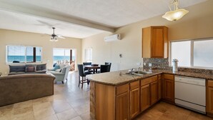 A spacious kitchen with wooden cabinets, a granite countertop, and a built-in dishwasher. - The Suites at Rocky Point 2 (Puerto Peñasco)