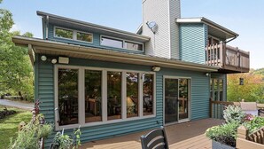 A two-story house with a deck, large windows, and a chimney. - One Minute to Road America - Close to PGA Golfing (Plymouth)