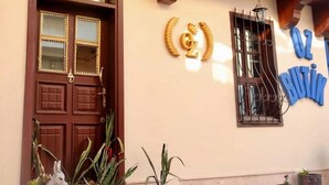 Fachada de edificio con puerta marrón, un letrero con el número '2' y detalles decorativos.