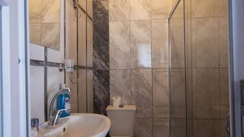 A bathroom with a sink, toilet, and shower.