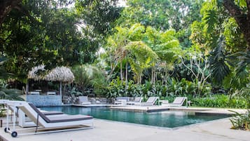 Una piscina al aire libre, sillones reclinables de piscina