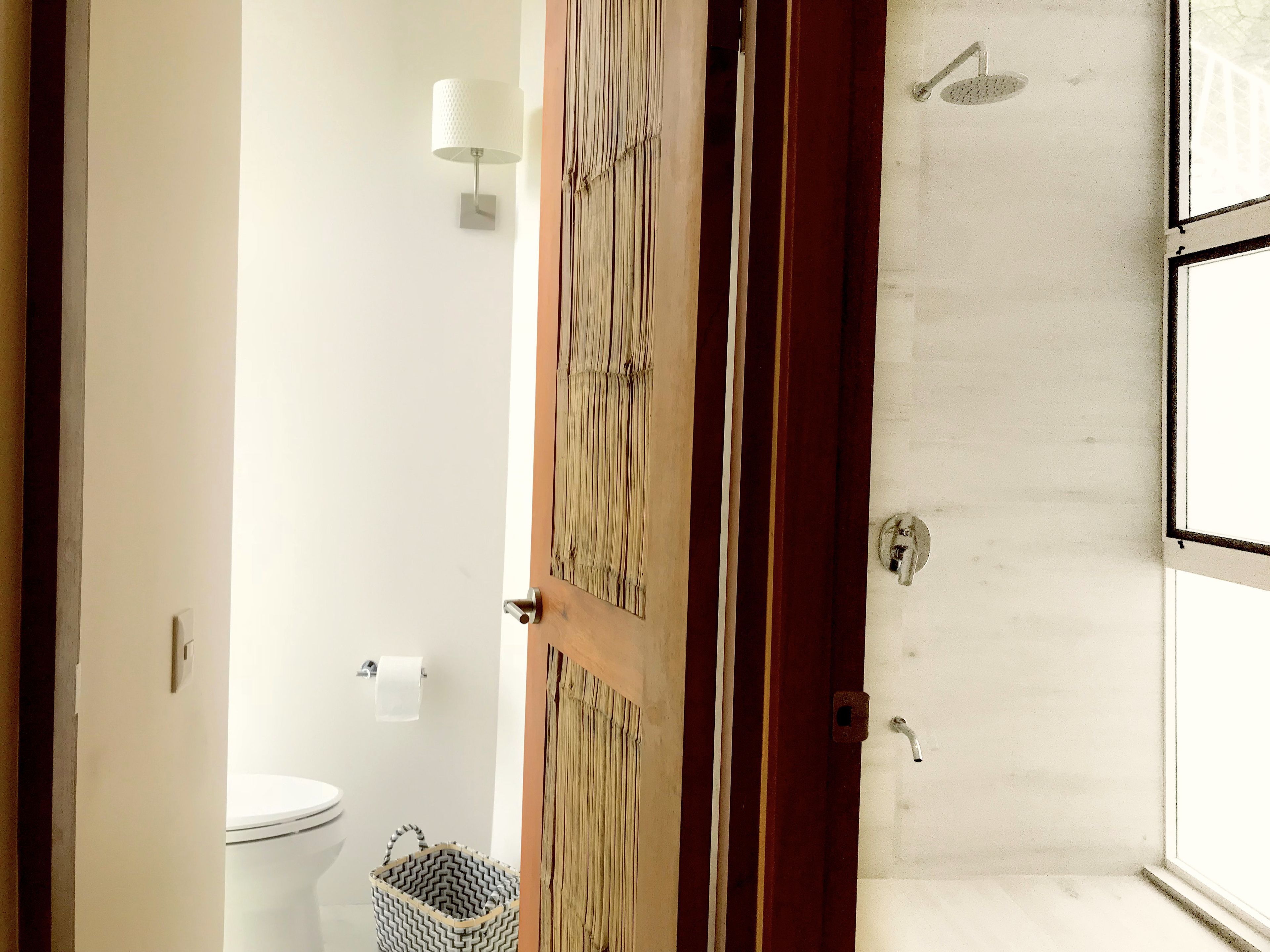 A bathroom with a toilet, a shower, and a towel rack.