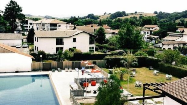 A residential area with a swimming pool, houses, and greenery. - Hôtel Bonnet (Saint-Pee-sur-Nivelle)