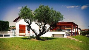 A white building with a red door and a tree in front. - Hôtel Bonnet (Saint-Pee-sur-Nivelle)