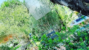 A garden area with a metal fence, benches, and a tiled walkway. - Grotta dei Puntali (Carini)
