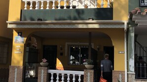 Un bâtiment à deux étages doté d’un balcon, d’une entrée fermée par un portail et d’une enseigne indiquant qu’il s’agit d’un restaurant.
