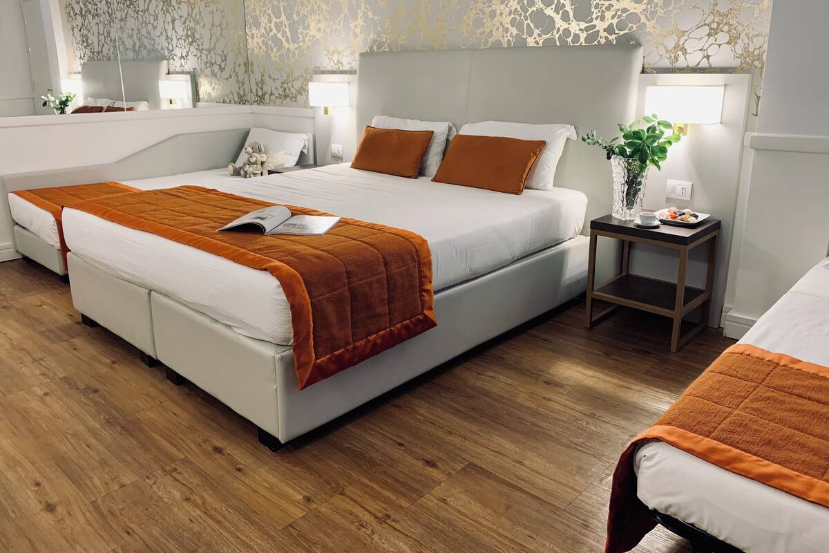 Un dormitorio moderno con una cama grande, dos mesitas de noche y un espejo.